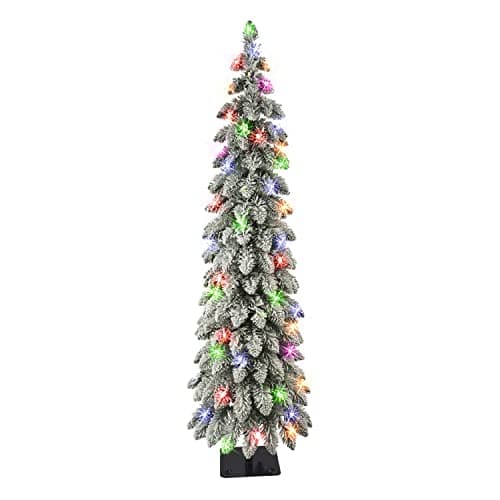 A slim lit Christmas tree in a pot by an entrance