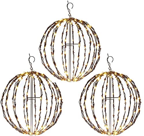 Large illuminated spheres hanging in a tree at night