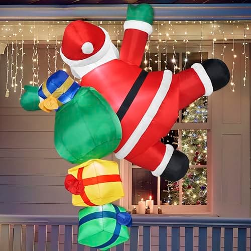 An inflatable Santa figure hanging from a roof edge