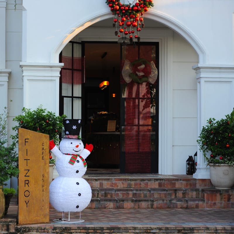 An inflatable Christmas figure on a front lawn at night