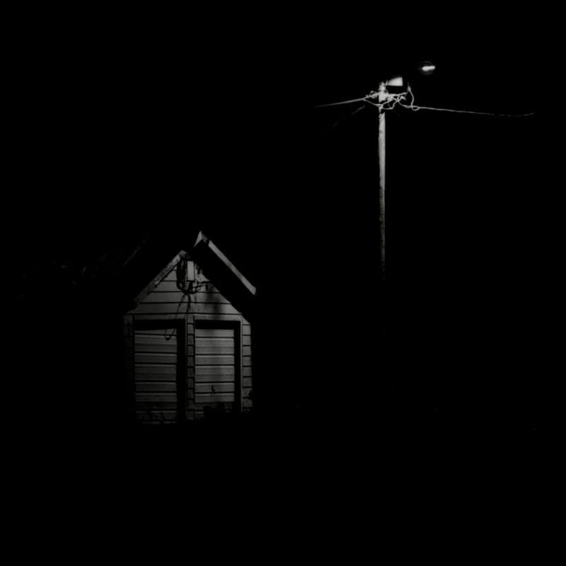 Projected light points across a house wall at night